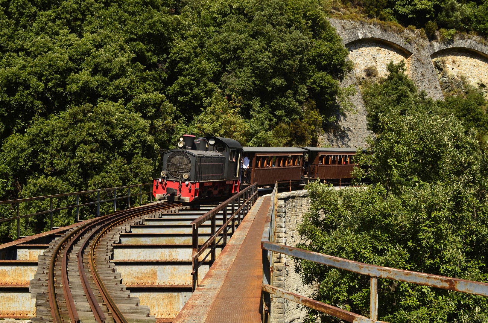 Greece,-the-Montzouris-Smudgy-train---Pelion-train---crossing-a-bridge---shutterstock_87084818